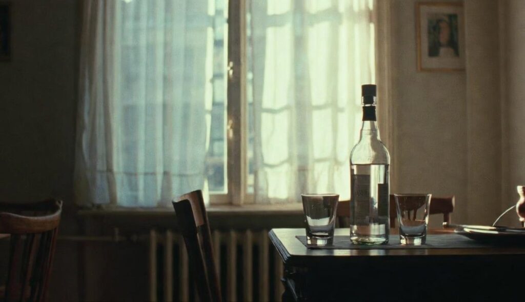en flaska starkstprit på ett bord i en lägenhet på femtiotalet